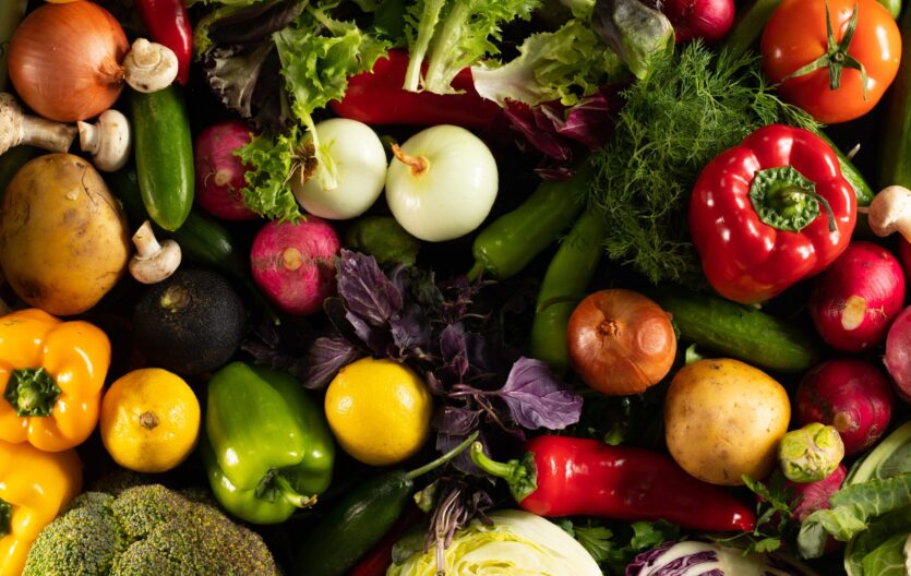 An overhead shot of different fresh vegetables put together on a black background